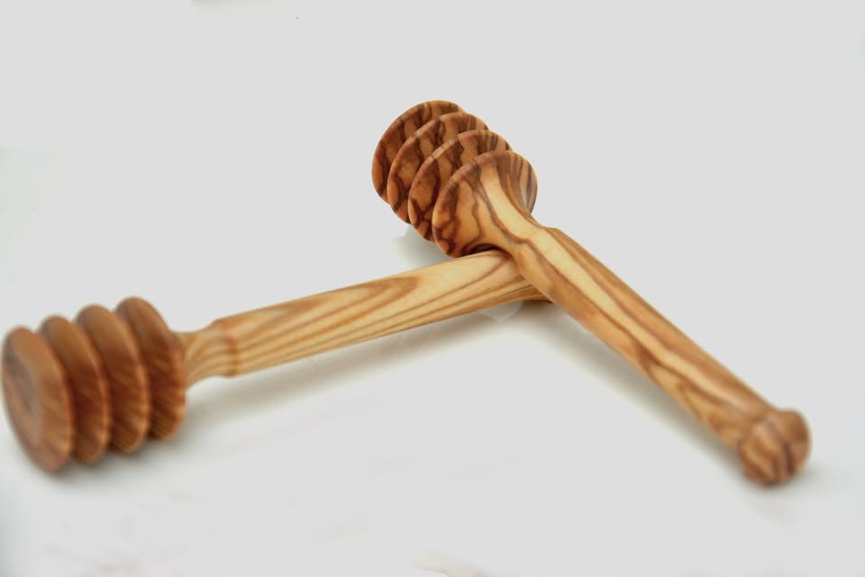 alt="Honiglöffel aus Olivenholz mit natürlicher Maserung, ideal zum Dosieren von Honig"