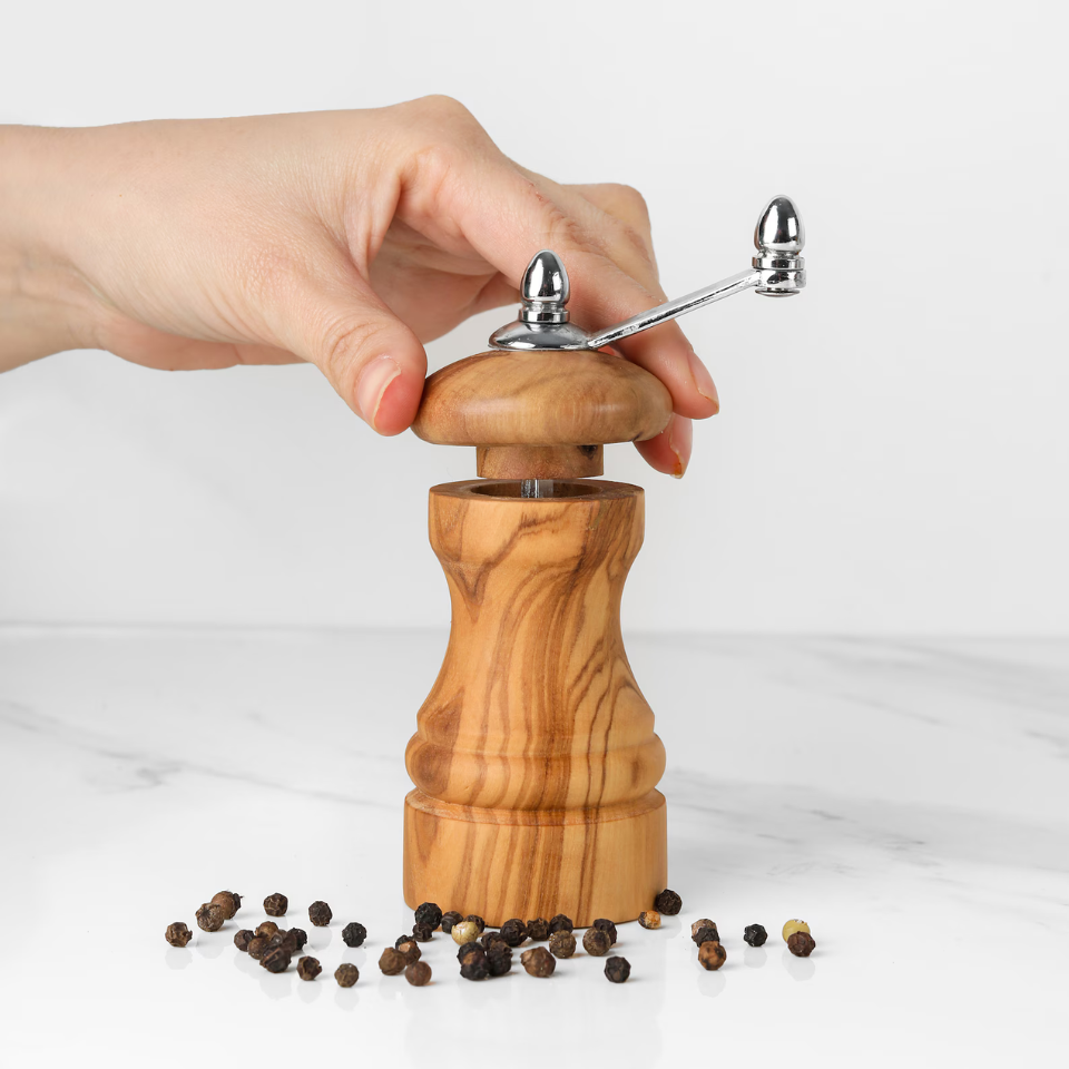alt="Salz- und Pfeffermühle aus Olivenholz mit natürlicher Maserung, ideal zum Würzen von Speisen"