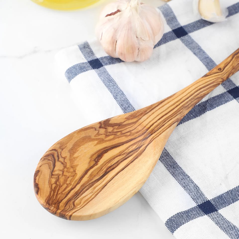 alt="Handgefertigter Kochlöffel aus Olivenholz mit natürlicher Maserung, ideal zum Kochen und Rühren"