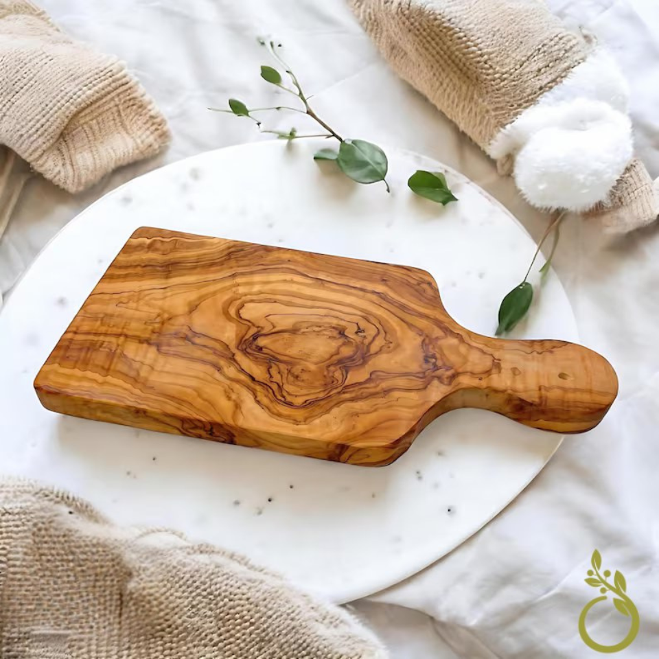 alt="Massives Schneidbrett aus Olivenholz mit Griff, ideal zum Schneiden und Servieren 25 cm"