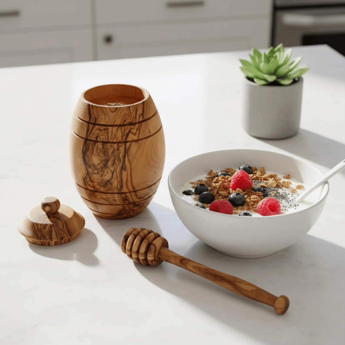 Mediterraner Honigtopf aus Olivenholz auf einem gedeckten Frühstückstisch