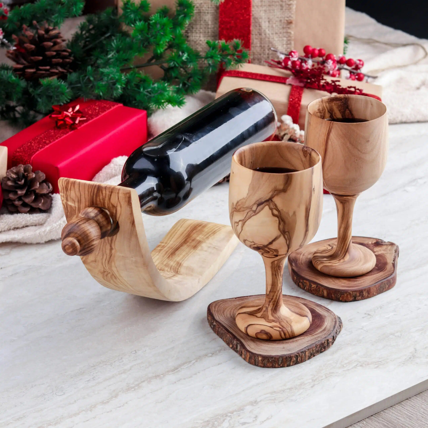 Geschenkset mit zwei handgefertigten Holzkelchen aus tunesischem Olivenholz, inklusive Flaschenhalter und Verschluss, auf mediterranem Hintergrund