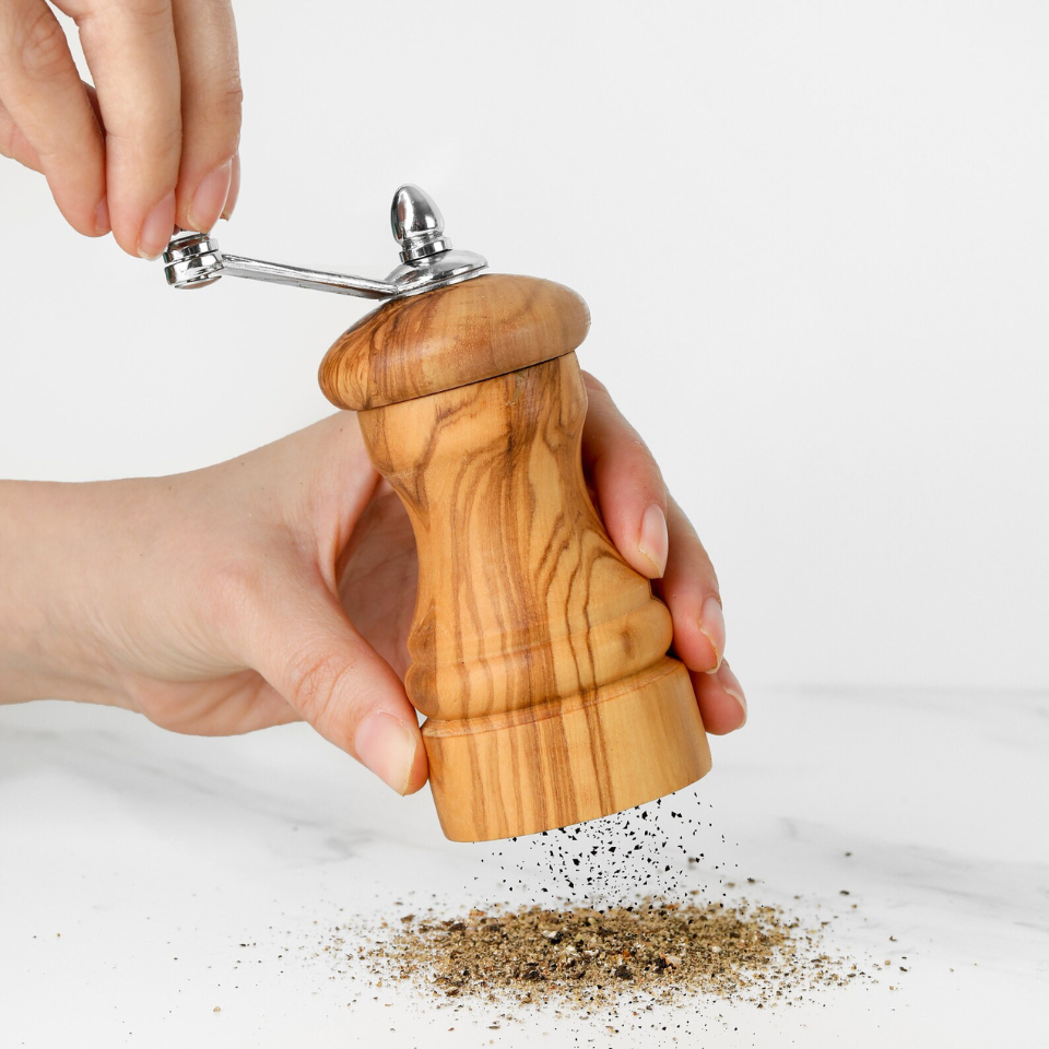 alt="Salz- und Pfeffermühle aus Olivenholz mit natürlicher Maserung, ideal zum Würzen von Speisen"