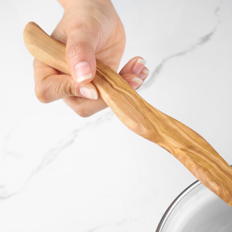 alt="Handgefertigter Kochlöffel aus Olivenholz, ergonomischer Griff, perfekt für Töpfe und Pfannen"