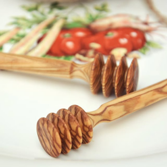 alt="Honiglöffel aus Olivenholz mit natürlicher Maserung, ideal zum Dosieren von Honig"