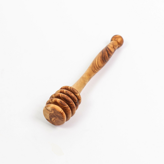 alt="Honiglöffel aus Olivenholz mit natürlicher Maserung, ideal zum Dosieren von Honig"