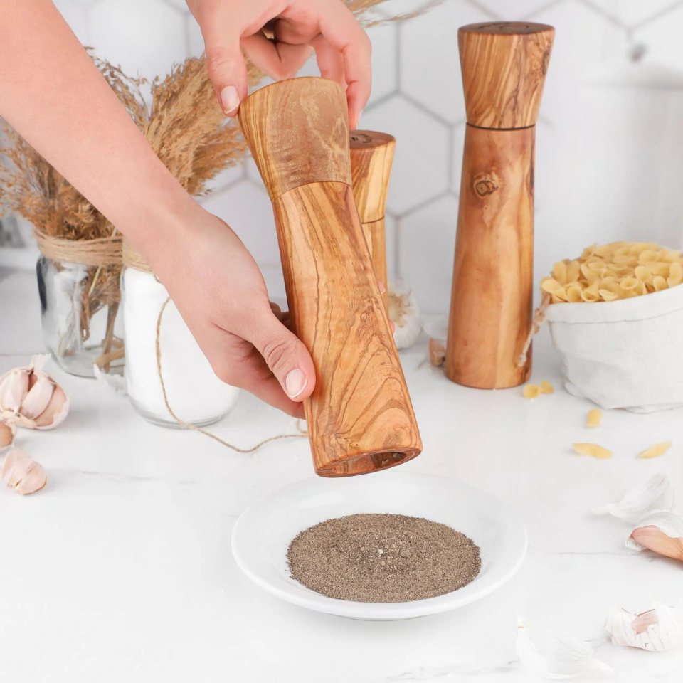 alt="Salz- und Pfeffermühle aus Olivenholz mit natürlicher Maserung, ideal zum Würzen von Speisen"